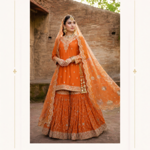 Rang-e-Noor Orange Embroidered Sharara Suit by Maharani Designer Boutique Add a vibrant touch of traditional elegance to your occasion wardrobe with the Rang-e-Noor Orange Embroidered Sharara Suit, a beautifully detailed Indian ethnic ensemble created for women who love rich colours, graceful silhouettes and timeless festive fashion. Presented by Maharani Designer Boutique, this orange sharara suit combines a richly coloured straight-cut kurta, beautifully embroidered sharara pants and an elegant matching dupatta to create a complete celebration-ready look. The vibrant orange tone gives the ensemble a warm, joyful and festive character, while delicate silver-gold-toned embroidery adds refinement throughout the outfit. The kurta features an intricately embroidered neckline, decorated cuffs and a detailed hemline, while small scattered motifs provide subtle embellishment across the body. The matching sharara features an all-over linear and geometric-inspired embroidered pattern, finished with an ornate border at the hem. Completing the look is a lightweight orange dupatta decorated with delicate motifs and an elaborate scalloped embroidered border. The coordinated embroidery creates harmony between all three components, making the outfit ideal for weddings, engagement celebrations, mehndi functions, sangeet ceremonies, festive gatherings, family celebrations and elegant traditional events. Designed for the modern woman who appreciates Indian craftsmanship with a graceful contemporary finish, the Rang-e-Noor Sharara Suit can be styled traditionally or given a more modern appearance depending on your jewellery, footwear, hairstyle and dupatta drape. Vibrant Orange Colour The standout feature of this ensemble is its beautiful orange colour. Orange is a naturally festive shade that brings warmth, energy and brightness to traditional Indian clothing. It is particularly suited to celebrations where vibrant colours create a lively and joyful atmosphere. The orange base also provides an attractive canvas for the intricate embroidery. The decorative work stands out against the rich fabric, creating a balanced combination of colour and embellishment. This makes the outfit especially suitable for daytime weddings, mehndi celebrations, festive gatherings and evening functions. For a softer daytime appearance, pair the suit with delicate jewellery and natural makeup. For an evening celebration, statement earrings, layered bangles and metallic accessories can enhance its glamorous character. Elegant Embroidered Kurta The kurta forms the central part of the Rang-e-Noor ensemble. Its clean silhouette provides an elegant foundation for the extensive decorative detailing. The neckline features concentrated embroidery that creates an attractive focal point around the face. The body of the kurta includes delicate scattered motifs, giving the fabric a refined embellished appearance without making the design feel overly dense. The lower hem is enhanced with a more elaborate embroidered border, visually connecting the kurta with the decorated sharara. This arrangement creates a beautiful progression from the neckline toward the hemline. Intricate Neckline Detailing The neckline features delicate traditional-inspired embroidery. The concentrated decoration draws attention toward the face and creates a natural frame for jewellery. A statement choker can be worn close to the neckline for a traditional wedding look. Alternatively, large earrings and a delicate necklace can create a more contemporary appearance. The embroidered neckline also means the outfit retains its visual appeal even when the dupatta is draped over one shoulder. Detailed Sleeves The full-length sleeves add elegance and sophistication to the ensemble. The cuffs feature intricate embroidery that mirrors the decorative language of the neckline and hem. This creates visual balance throughout the kurta. The sleeve detailing also works beautifully with traditional bangles and bracelets. For a formal wedding appearance, stack gold-toned bangles with a few statement pieces. For a modern festive look, choose fewer accessories and allow the embroidered cuffs to remain visible. Embroidered Kurta Hem The lower edge of the kurta features an ornate embroidered border. This detailing provides a visual transition between the shorter kurta and the flowing sharara. The embroidery incorporates traditional decorative motifs, giving the outfit a distinctly Indian character. The detailed hem becomes particularly noticeable when the wearer moves, allowing the embroidery to complement the movement of the sharara. Flared Sharara Pants The sharara is an important feature of this ensemble. Its wide, flowing silhouette creates graceful movement and gives the outfit a festive appearance. The orange sharara is decorated with an all-over linear embroidered pattern, creating texture and visual interest across the fabric. The flared shape adds volume while maintaining a lightweight and elegant appearance. As you walk or move, the pleated and flowing fabric creates a beautiful rhythmic effect. This makes the outfit particularly attractive for celebrations involving movement, dancing and photography. Intricate Sharara Embroidery The embroidery across the sharara features repeated vertical and geometric-inspired patterns. The arrangement creates elongated lines that visually complement the wide silhouette. Rather than relying solely on large motifs, the design uses repeated detailing to create a refined surface. The lower section features an ornate embroidered border that provides a strong finishing point. This combination of all-over embroidery and a detailed hem gives the sharara a luxurious appearance. Statement Sharara Border The embroidered border at the bottom of the sharara provides a beautiful finishing detail. Its decorative pattern coordinates with the kurta hem and dupatta border, creating a unified ensemble. The border becomes especially prominent when the sharara flares during movement. It can also be highlighted in seated photographs, close-up detail shots and traditional wedding portraits. Designer Orange Dupatta The matching dupatta completes the Rang-e-Noor Sharara Suit. Designed in the same vibrant orange colour, it features delicate decorative motifs distributed across the fabric. The dupatta is finished with a richly embroidered scalloped border. This border adds definition to the lightweight fabric and gives the overall outfit a polished designer appearance. The dupatta can be draped over one shoulder, across both arms or over the head depending on the occasion. Scalloped Dupatta Border One of the most attractive details of the dupatta is its decorative scalloped edge. The embroidered border provides a soft yet elaborate finish. When the dupatta is draped over the shoulder, the border creates a beautiful decorative line alongside the kurta and sharara. When placed over the head, it creates a traditional silhouette suitable for wedding ceremonies and formal family occasions. Perfect Orange Wedding Suit The Rang-e-Noor ensemble is an excellent option for women looking for an orange wedding suit with a distinctive festive character. Orange is especially suitable for pre-wedding celebrations, mehndi ceremonies and daytime functions. The elaborate embroidery elevates the colour, making the outfit suitable for formal occasions rather than everyday wear. Pair it with traditional earrings, bangles and embroidered footwear for a complete wedding look. Orange Sharara Suit for Mehndi The vibrant colour makes this outfit especially suitable for mehndi celebrations. Mehndi events often feature colourful décor, floral arrangements and festive lighting, making bright orange an excellent choice. For a playful mehndi look, pair the outfit with colourful bangles and statement earrings. Floral accessories can also be introduced for a softer appearance. A traditional jutti or embroidered sandal can complete the styling. Orange Sharara for Sangeet The flowing sharara silhouette makes the outfit an excellent option for a sangeet celebration. Its wide shape creates movement while walking and dancing, giving photographs an attractive sense of motion. For sangeet styling, consider wearing the dupatta over one shoulder to keep the hands and arms more comfortable. Statement earrings, bangles and a decorative clutch can provide the finishing touches. Engagement Outfit The Rang-e-Noor Sharara Suit can also be styled for an engagement celebration. For an elegant engagement appearance, choose refined gold-toned jewellery and a polished hairstyle. A statement choker can emphasize the embroidered neckline. Alternatively, chandelier earrings can be used as the main jewellery feature. A neatly draped dupatta can create a sophisticated silhouette suitable for formal engagement photography. Festive Indian Wear The ensemble can be worn for a variety of festive occasions. Its bright colour and traditional embroidery make it appropriate for celebrations such as: Diwali gatherings Family celebrations Traditional dinners Wedding functions Puja celebrations Festive parties Cultural events Formal family gatherings The outfit can be dressed up or down through accessories and styling. Traditional Jewellery Styling Traditional jewellery complements the Indian character of this ensemble beautifully. Jhumkas Large jhumkas provide a classic Indian finishing touch. Choker A traditional choker can emphasize the neckline embroidery. Kundan-Inspired Jewellery Kundan-inspired pieces can create a regal appearance. Gold Jewellery Gold-toned jewellery naturally complements the embroidery. Bangles Stacked bangles create a festive bridal-inspired appearance. Maang Tikka For weddings, a maang tikka can add traditional elegance. Statement Ring A decorative ring can complete the jewellery styling without adding excessive layers. Hairstyle Ideas The outfit works beautifully with traditional and contemporary hairstyles. Low Bun A low bun creates a polished appearance and keeps attention on the neckline and earrings. Centre-Parted Bun A centre-parted bun with a maang tikka provides a classic Indian wedding look. Soft Waves Loose waves give the traditional outfit a contemporary finish. Side-Swept Curls Side-swept curls create a glamorous evening appearance. Floral Bun Fresh flowers can be added to a traditional bun for mehndi or wedding celebrations. Makeup Suggestions The vibrant orange shade works particularly well with warm makeup tones. Consider: Defined eyes Soft bronze or gold eyeshadow Warm blush Natural highlighter Defined brows Peach or coral lipstick For an evening event, a slightly deeper lip colour can create more drama. For daytime functions, keep the makeup fresh and luminous. The final makeup should complement your individual complexion and personal style. Footwear Styling The wide sharara silhouette can be paired with several footwear options. Recommended choices include: Gold heels Embellished sandals Traditional juttis Embroidered mojaris Metallic heels Neutral sandals Choose footwear based on comfort, event duration and the desired height. For weddings and long celebrations, comfortable embellished juttis or supportive heels can be practical choices. Clutch and Potli Styling A coordinated handbag can complete the look. Gold clutches work beautifully with the embroidered detailing. An orange or coral clutch can create a monochromatic appearance. A traditional potli bag can enhance the ethnic character of the ensemble. For contemporary events, a structured metallic clutch can provide a sophisticated contrast. Dupatta Draping Ideas The dupatta can be styled in different ways. One-Shoulder Drape Allow the dupatta to fall over one shoulder while displaying the embroidered border. Front Drape Bring the decorated border toward the front to showcase its embroidery. Head Drape For traditional ceremonies, place the dupatta over the head. Two-Shoulder Drape Let the dupatta fall across both shoulders for a balanced formal appearance. Daytime Wedding Styling The orange colour makes this ensemble particularly attractive for daytime celebrations. Pair it with delicate jewellery, soft makeup and traditional footwear. A simple hairstyle can maintain an elegant and fresh appearance. Allow the bright orange colour to remain the main visual feature while using gold accessories to highlight the embroidery. Evening Styling For an evening celebration, increase the glamour through jewellery and accessories. Choose statement earrings, a traditional choker, stacked bangles and an embellished clutch. A polished bun or flowing waves can complement the silhouette. Warm evening lighting can beautifully highlight the decorative embroidery against the orange base. Contemporary Styling Although the design has a distinctly traditional character, it can easily be styled in a contemporary way. Wear the dupatta over one shoulder. Choose oversized earrings instead of layered necklaces. Pair the ensemble with modern metallic heels. Keep the hairstyle loose and polished. This creates a fashionable fusion appearance while retaining the beauty of the original Indian silhouette. Traditional Styling For a more traditional look, style the outfit with: Maang tikka Choker necklace Jhumkas Gold bangles Traditional juttis Head-draped dupatta This styling works especially well for weddings and religious or family celebrations. Why Choose the Rang-e-Noor Sharara Suit? The Rang-e-Noor Orange Embroidered Sharara Suit brings together colour, embroidery and graceful movement in a complete Indian occasion-wear ensemble. Key Highlights Vibrant orange colour Embroidered straight-cut kurta Detailed neckline Full embroidered sleeves Decorative kurta hem Wide flared sharara All-over sharara embroidery Ornate sharara border Matching embroidered dupatta Scalloped dupatta border Traditional Indian-inspired detailing Suitable for weddings and festive occasions Versatile styling options Elegant choice for modern Indian celebrations Ideal for Women Who Love Statement Ethnic Wear This ensemble is designed for women who want their traditional clothing to feel distinctive. The bright orange colour immediately creates a festive impression, while the embroidery adds sophistication. The combination of a shorter kurta and wide sharara creates a graceful silhouette with plenty of movement. The matching dupatta completes the outfit and provides multiple styling possibilities. Whether you are attending a wedding, celebrating a festival or participating in a family event, this ensemble allows you to create an elegant and memorable appearance. Maharani Designer Boutique Maharani Designer Boutique brings together traditional Indian aesthetics and contemporary occasion-wear styling for women seeking elegant outfits for important celebrations. The Rang-e-Noor Orange Embroidered Sharara Suit reflects this design philosophy through its vibrant colour, ornate embroidery and flowing silhouette. The ensemble is suitable for women looking for orange sharara suits, wedding suits, embroidered ethnic wear, festive suits and designer Indian outfits. Its coordinated kurta, sharara and dupatta create a complete look, reducing the need to search for separate pieces to match. With the right jewellery, footwear, hairstyle and makeup, the same outfit can be styled differently for a mehndi, sangeet, wedding, engagement or festive celebration. Product Details Product Name: Rang-e-Noor Orange Embroidered Sharara Suit Brand: Maharani Designer Boutique Category: Designer Sharara Suit Colour: Orange Kurta: Embroidered orange kurta with detailed neckline, sleeves and hem Bottom: Flared embroidered sharara Dupatta: Matching orange embroidered dupatta with decorative scalloped border Embroidery: Traditional-inspired floral, ornamental and geometric detailing Style: Indian Ethnic / Festive / Wedding Wear Occasions: Wedding, Mehndi, Sangeet, Engagement, Festive Celebrations, Family Functions and Party Wear Product note: Exact fabric composition, measurements, lining, customization options, embroidery technique and accessories included should be confirmed with Maharani Designer Boutique before purchase, as these specifications cannot be reliably determined from the product image alone. Care & Storage Instructions Because this is an embellished occasion-wear ensemble, careful storage and handling are recommended. Keep the outfit in a clean, breathable garment bag when not in use. Avoid prolonged exposure to direct sunlight. Keep the embroidery away from rough surfaces that could catch or pull decorative threads. Avoid applying perfume, hairspray or cosmetic products directly onto the fabric. After wearing, allow the outfit to air appropriately before storing it. The dupatta should be folded carefully to protect its embroidered scalloped border. When travelling with the outfit, use protective layers to minimize friction against the embroidery. Follow the care instructions supplied with the actual garment. Professional cleaning may be suitable depending on the final fabric and embellishment construction. orange sharara suit, orange sharara suit for wedding, orange wedding suit, orange wedding suit for women, orange designer suit, orange designer sharara, orange heavy suit, orange heavy embroidered suit, orange embroidered suit, orange party wear suit, orange party wear sharara, orange bridal suit, orange wedding sharara, orange Indian suit, orange ethnic wear, orange ethnic suit, orange festive suit, orange festive wear, orange gold suit, orange and gold sharara, orange and gold wedding suit, embroidered orange suit, heavy embroidery sharara suit, heavy embroidered sharara, designer sharara suit, designer sharara suit online, designer wedding suit, designer wedding wear, designer party wear suit, designer ethnic wear, luxury sharara suit, luxury Indian suit, royal sharara suit, royal wedding suit, traditional sharara suit, traditional Indian suit, traditional wedding wear, Indian wedding suit for women