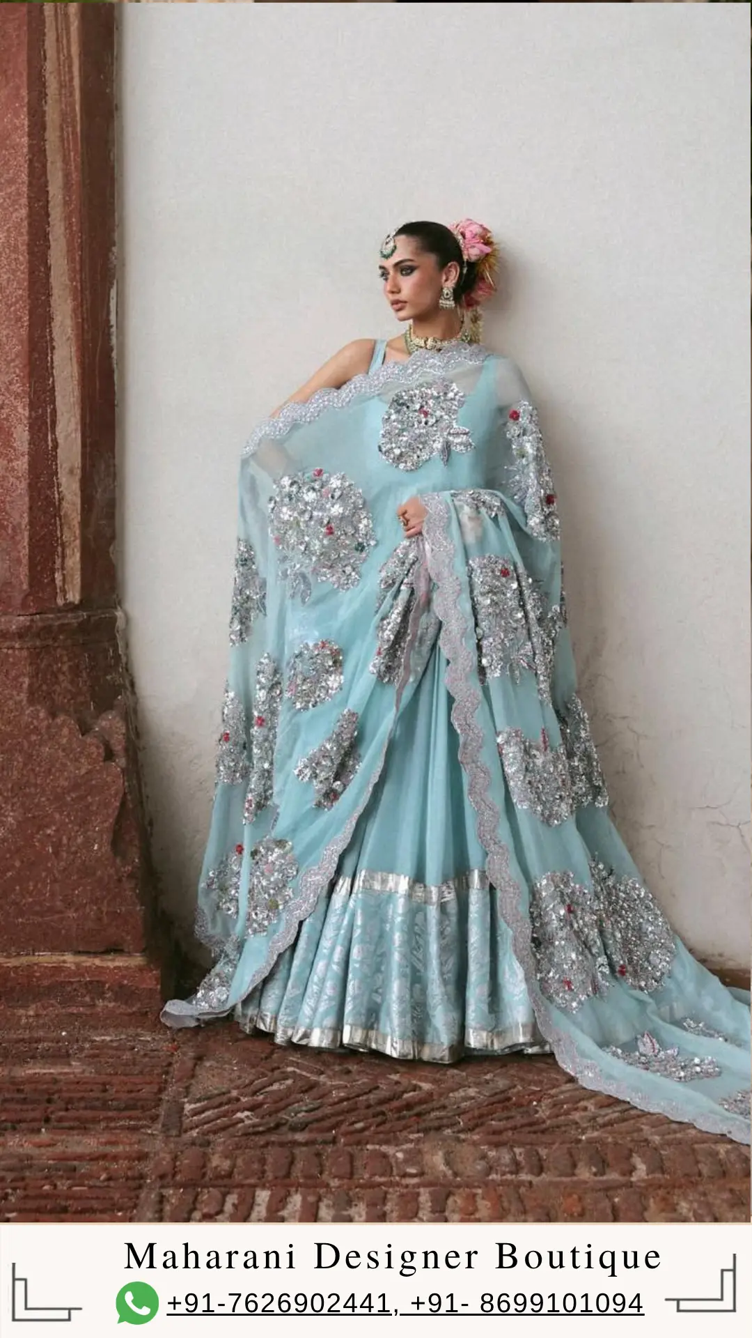 Pastel Aqua Blue Anarkali Gown – A Dreamy Expression of Contemporary Indian Couture Make a graceful statement at your next celebration with this Pastel Aqua Blue Anarkali Gown with Silver Floral Embroidery, an exquisite designer ensemble created for women who love soft pastel colours, luxurious embellishment, flowing silhouettes, and elegant Indian craftsmanship. The outfit features a beautiful pastel aqua blue base adorned with intricate silver-toned floral embroidery and shimmering embellishment. Delicate hints of pink and red add subtle colour to the floral motifs, creating a sophisticated contrast against the cool blue background. The flowing Anarkali-style silhouette gives the outfit a graceful fall, while the richly decorated lower section adds volume, texture, and movement. A beautifully coordinated sheer dupatta completes the ensemble. Covered with ornate floral motifs and finished with a scalloped embroidered border, the dupatta creates an elegant layered effect and adds a luxurious finishing touch to the outfit. This designer Anarkali suit is an ideal choice for weddings, engagement ceremonies, receptions, sangeet celebrations, festive gatherings, formal dinners, destination weddings, and other special occasions where you want your outfit to feel sophisticated and memorable. The combination of pastel aqua blue, silver embroidery, floral detailing, and a dramatic flowing silhouette creates a look that feels both traditional and contemporary. A Beautiful Pastel Aqua Blue Colour The soft aqua blue shade gives this outfit its distinctive personality. Pastel blue has become a favourite in contemporary Indian occasion wear because it offers a refreshing alternative to conventional reds, maroons, oranges, and jewel tones. It creates a softer and more sophisticated appearance while still allowing elaborate embroidery and embellishment to take centre stage. In this design, the aqua blue base provides a serene canvas for the silver floral embroidery. The cool blue tone allows the metallic detailing to appear luminous, while tiny pink and red accents add warmth to selected floral motifs. The resulting colour palette feels elegant, feminine, and refined. It is especially suited to women who want an occasion outfit that feels luxurious without appearing excessively heavy in colour. The pastel shade also photographs beautifully, making this ensemble an excellent choice for wedding photography, engagement portraits, family photographs, and festive celebrations. Intricate Silver Floral Embroidery The defining feature of this Anarkali ensemble is its elaborate floral embroidery. Large floral motifs are carefully positioned across the front of the outfit, creating eye-catching focal points. Smaller floral details and ornamental patterns extend across different sections, giving the garment a beautifully layered appearance. The silver-toned embellishment creates a subtle shimmer against the pastel aqua blue background. The floral motifs are not limited to one section of the garment. They continue across the bodice, flowing skirt, sleeves, and dupatta, creating a coordinated visual story throughout the entire ensemble. This continuity gives the outfit a couture-inspired appearance. The silver detailing can catch the light beautifully as the wearer moves, creating a soft luminous effect that is particularly attractive for evening events. Graceful Anarkali Silhouette The flowing Anarkali-inspired silhouette creates one of the most elegant features of the ensemble. The bodice follows a structured form before opening into a generous flare. The lower portion spreads gracefully around the body, creating movement and volume without compromising the feminine shape of the outfit. The silhouette is particularly beautiful when walking because the fabric moves naturally with every step. The flare also allows the embroidered details to become visible from different angles. For wedding entrances, receptions, photographs, and formal celebrations, a flowing Anarkali silhouette can create a dramatic yet graceful appearance. The design balances traditional Indian dressing with a contemporary sense of proportion, making it suitable for women who want the elegance of a traditional ensemble with a modern finish. Beautifully Detailed Lower Section The lower section of the Anarkali is richly detailed with patterned embroidery and a statement metallic-toned hem. The flared portion appears to feature intricate repeating patterns that add depth to the pastel blue base. Near the hem, the design becomes more elaborate, creating a stronger visual finish. The metallic border defines the bottom of the garment and gives the flowing silhouette structure. As the wearer moves, the border creates a beautiful visual rhythm around the flare. This combination of detailed fabric, embroidery, and a defined hem makes the lower portion particularly attractive in full-length photographs. The flare also creates a regal effect when the outfit is spread or photographed while walking. Statement Sheer Dupatta The dupatta adds another layer of elegance to this ensemble. Designed in a lightweight, sheer-looking pastel aqua blue fabric, it allows the colour of the outfit underneath to remain visible while introducing additional embroidery and embellishment. Large floral motifs decorate the dupatta, creating continuity with the main Anarkali. The border is one of the most striking features. A delicate scalloped edge runs along the perimeter, decorated with intricate silver-toned embroidery. The scalloped finish creates a softer and more feminine appearance than a straight border. The dupatta can be draped over one shoulder, arranged across both arms, or styled over the head for a more traditional Indian appearance. For bridal or wedding ceremonies, wearing the dupatta over the head can create a graceful and ceremonial look. For a reception or cocktail-style celebration, draping it over one shoulder can create a more contemporary silhouette. Floral Motifs with Subtle Colour Accents The floral motifs are primarily silver and metallic in appearance, but subtle touches of pink and red can be seen within selected embellishments. These small colour accents are important because they prevent the silver detailing from appearing too monochromatic. The soft pink tones complement the aqua blue beautifully, while the occasional deeper accents create visual depth. The floral arrangement gives the outfit a romantic personality while maintaining the grandeur expected from designer occasion wear. The result is a design that feels feminine without becoming overly delicate. Perfect for Weddings This pastel blue designer Anarkali is a beautiful option for wedding celebrations. Its soft colour palette makes it suitable for a range of wedding functions, while the intricate embroidery provides enough richness for formal occasions. It can be styled for: Wedding receptions Engagement ceremonies Sangeet celebrations Mehendi functions Family weddings Cocktail evenings Festive celebrations Destination weddings Formal dinners Anniversary celebrations Cultural events Wedding guest dressing Pre-wedding celebrations For a daytime wedding, pair it with delicate jewellery and soft makeup. For an evening reception, add statement earrings, a glamorous clutch, and more defined makeup. The outfit can therefore be adapted to suit the mood and timing of the celebration. Elegant Engagement Outfit Engagement ceremonies are ideal occasions for pastel colours. This aqua blue Anarkali provides a sophisticated alternative to traditional engagement outfits in darker shades. The colour feels fresh and celebratory, while the silver embellishment provides enough glamour for photographs and formal festivities. Pair the outfit with a statement choker, elegant earrings, soft curls, and luminous makeup for a romantic engagement look. For a more contemporary appearance, wear statement earrings without a necklace. This keeps the neckline visible and allows the embroidery to become the focal point. A delicate maang tikka can also be added for a more traditional Indian styling. Perfect for Reception Wear The intricate embroidery and shimmering detailing make this ensemble especially appropriate for a wedding reception. Reception events often call for outfits that feel glamorous while remaining elegant. The flowing silhouette creates a sophisticated evening appearance, while the pastel colour keeps the outfit from appearing overly heavy. For a reception, style the ensemble with: Statement earrings A delicate or statement necklace Metallic clutch Embellished footwear Soft waves or a sleek bun Luminous makeup Subtle highlighter The silver embellishment will naturally complement metallic accessories and evening lighting. Beautiful Sangeet Styling The flowing silhouette makes this ensemble suitable for sangeet celebrations. The flare provides movement, making the outfit visually appealing while walking, posing, and dancing. For a sangeet, the dupatta can be secured neatly over one shoulder or arranged around the arms so that the wearer can move comfortably. Statement earrings and a sleek hairstyle can create a modern party look. Alternatively, traditional jewellery and bangles can give the outfit a more classic Indian character. The versatility of the silhouette allows the styling to change according to personal preference. Festive Indian Wear with a Modern Touch This ensemble demonstrates how Indian occasion wear can incorporate traditional detailing while maintaining a contemporary colour palette. The Anarkali silhouette is deeply rooted in Indian fashion, but the pastel aqua blue colour and silver embellishment give the design a modern identity. It is suitable for women who appreciate traditional craftsmanship but prefer lighter, fresher colours. The outfit can be worn for festive celebrations, family gatherings, cultural occasions, formal dinners, and special celebrations. Its sophisticated colour palette also makes it suitable for women who prefer understated luxury. Jewellery Styling The cool pastel blue and silver colour combination creates many jewellery possibilities. For a traditional Indian appearance, pair the outfit with a silver-toned, diamond-inspired, or crystal jewellery set. Pearl jewellery can also complement the soft pastel palette beautifully. For a more traditional wedding appearance, choose jewellery featuring silver, white stones, pearls, or subtle pastel accents. For a modern reception, large statement earrings may be enough. A choker can beautifully frame the neckline, while a longer necklace can add another layer of elegance. Bangles can be selected in silver, crystal, pearl, or complementary pastel shades. The jewellery should ideally complement rather than compete with the elaborate floral embroidery. Hairstyle Suggestions A sleek low bun is a timeless option for this Anarkali. It keeps the neckline and jewellery visible and creates a polished formal appearance. For a traditional wedding look, a centre-parted bun decorated with flowers can beautifully complement the pastel colour palette. For an engagement or reception, soft waves can create a more contemporary and romantic appearance. Loose curls can also work beautifully with the flowing silhouette. If the dupatta is worn over the head, a neat bun becomes particularly practical and elegant. Makeup Suggestions The pastel aqua blue shade works beautifully with luminous makeup. For daytime celebrations, choose fresh skin, softly defined eyes, rosy cheeks, and a nude-pink or soft rose lip. For evening functions, add subtle shimmer to the eyes and more defined eyeliner. Silver or champagne-toned eyeshadow can complement the embroidery without overpowering the outfit. A soft pink, mauve, rose, or berry-toned lip can work beautifully depending on the desired intensity. The overall makeup should maintain balance between the soft colour palette and the statement embroidery. Destination Wedding Style Pastel colours are particularly attractive for destination weddings. This aqua blue Anarkali can create an elegant appearance against heritage architecture, palace-inspired venues, luxury hotels, gardens, and outdoor wedding locations. The flowing silhouette photographs beautifully against architectural backgrounds. The sheer embroidered dupatta can also create movement in outdoor photographs, especially when styled over one shoulder or allowed to flow naturally. For a destination wedding, pair the outfit with lightweight statement jewellery and a structured clutch. Photography-Friendly Design A special occasion outfit should look beautiful from every angle. This design contains several elements that create visual interest in photographs. The large floral motifs provide close-up details. The flowing flare creates movement in full-length photographs. The metallic border defines the lower silhouette. The sheer dupatta adds depth and transparency. The scalloped embroidered border provides an elegant frame. The pastel aqua blue colour creates a soft visual contrast against traditional architecture, neutral interiors, gardens, and wedding décor. Together, these elements make the outfit particularly suitable for photography. A Feminine and Sophisticated Silhouette The overall design is feminine without being excessively ornate in colour. The pastel base keeps the outfit visually soft, while the extensive silver embellishment provides the required richness. The flowing skirt-like lower portion creates a graceful silhouette, while the fitted upper section gives the outfit structure. This balance allows the ensemble to feel elegant and comfortable while maintaining the grandeur of designer occasion wear. Suitable for Wedding Guests Although the design has a luxurious bridal-inspired aesthetic, it can also be styled beautifully as a wedding guest outfit. For a wedding guest, keep the jewellery slightly lighter and allow the embroidery to remain the focus. A statement earring, elegant clutch, soft hairstyle, and refined makeup can create a polished appearance. For close family members, the jewellery can be increased to create a more elaborate festive look. This versatility makes the ensemble suitable for different roles within a wedding celebration. Contemporary Indian Couture Indian couture is increasingly influenced by a combination of traditional craftsmanship and modern styling. This ensemble reflects that approach through its traditional Anarkali silhouette, floral embroidery, embellished dupatta, and metallic detailing, while the pastel aqua blue palette provides a contemporary aesthetic. It is ideal for women who want their Indian clothing to feel luxurious but not overly traditional. The design can be styled traditionally with classic jewellery or modernised through contemporary accessories. Custom-Made Designer Experience At Maharani Designer Boutique, selected designer outfits can be developed with individual measurements and styling preferences in mind. For made-to-order or customised versions, customers can discuss fitting requirements, measurements, neckline preferences, sleeve styling, dupatta arrangement, and other design considerations where applicable. Customers ordering for a specific wedding or celebration are encouraged to share their event date in advance. This allows the appropriate production timeline to be discussed before confirming the order. Because detailed occasion wear requires careful embroidery, finishing, and construction, production timelines may vary depending on the design and level of customisation. Ideal for Women Who Love Pastel Luxury Pastel luxury is about combining soft colours with refined craftsmanship. This outfit is perfect for women who want an elegant colour palette without sacrificing intricate detailing. The aqua blue base creates softness. The silver embroidery adds glamour. The floral motifs create romance. The flowing silhouette adds grace. The embellished dupatta provides drama. The overall effect is luxurious, feminine, and sophisticated. Styling for Different Occasions The versatility of this Anarkali allows you to create different looks through accessories. For an engagement, pair it with delicate jewellery and soft curls. For a sangeet, choose statement earrings and a contemporary hairstyle. For a reception, add a statement necklace, metallic clutch, and glamorous makeup. For a festive celebration, choose traditional jewellery and bangles. For a daytime wedding, keep the accessories light and let the pastel colour shine. This adaptability makes the ensemble a beautiful investment for an occasion-wear wardrobe. Indian Wear for Global Celebrations Indian weddings and celebrations are enjoyed across the world, and pastel designer outfits have become increasingly popular among women looking for elegant ethnic wear outside India. This ensemble can be styled for Indian weddings, receptions, engagement celebrations, Diwali gatherings, cultural events, and family functions in India as well as international destinations. Maharani Designer Boutique caters to customers seeking premium Indian occasion wear with PAN India and worldwide shipping options. Whether you are shopping from Jalandhar or preparing for a wedding abroad, you can discuss measurements, availability, customisation, and delivery requirements with the boutique. Care and Storage Because this outfit features detailed embroidery and embellishment, careful handling is recommended. Store the ensemble in a clean and dry garment bag when not in use. Avoid placing heavy objects directly over embroidered sections. The dupatta should be folded or stored carefully to help protect its embroidered border and decorative motifs. For cleaning, follow the care instructions appropriate to the actual fabric and embellishments used in the finished garment. Professional cleaning is recommended for heavily embellished occasion wear. Why Choose This Designer Anarkali? This ensemble is an excellent choice if you are searching for: A pastel blue designer Anarkali A luxury Indian occasion outfit An embroidered Anarkali suit A wedding guest outfit An engagement outfit A reception outfit A sangeet outfit A festive Indian outfit A pastel wedding outfit A floral embroidered suit A designer Anarkali with dupatta A custom-made Indian outfit Premium ethnic wear Contemporary Indian couture A Timeless Occasion-Wear Investment Trends may change, but elegant Indian silhouettes remain timeless. The Anarkali has continued to evolve across generations because of its ability to create a graceful, feminine silhouette while offering endless opportunities for embroidery, colour, and styling. This pastel aqua blue version gives the classic silhouette a contemporary personality. The soft colour makes it suitable for multiple occasions, while the intricate embroidery ensures that it remains a statement piece. It can become part of your festive wardrobe for weddings, receptions, engagement celebrations, and other important events. Final Look This Pastel Aqua Blue Anarkali Gown with Silver Floral Embroidery and Embellished Dupatta is a celebration of elegance, craftsmanship, colour, and movement. The soft aqua blue base creates an ethereal appearance, while the intricate silver floral embellishment adds luxury and sophistication. Subtle pink and red accents give the floral motifs additional depth. The flowing Anarkali silhouette creates graceful movement, while the richly decorated lower section and metallic-toned hem provide structure. The embroidered sheer dupatta completes the outfit with statement floral motifs and a beautifully scalloped border. Whether you are attending a wedding reception, engagement, sangeet, festive celebration, destination wedding, or formal family occasion, this designer ensemble offers an elegant and memorable way to dress for the moment. Discover premium designer Indian occasion wear at Maharani Designer Boutique, where traditional craftsmanship meets contemporary styling. For current availability, pricing, measurements, customisation, production timeline, fabric details, and shipping information, contact the boutique directly before placing your order. Maharani Designer Boutique Jalandhar, Punjab, India PAN India & Worldwide Shipping WhatsApp: +91 7626902441 | +91 8699101094 Product Highlights Pastel aqua blue designer Anarkali Flowing flared silhouette Intricate silver floral embroidery Subtle pink and red embroidery accents Heavily embellished front motifs Detailed lower skirt section Metallic-toned hem detailing Sheer-style embroidered dupatta Floral dupatta motifs Scalloped embroidered dupatta border Elegant contemporary Indian design Ideal for weddings and receptions Perfect for engagement and sangeet functions Suitable for festive celebrations Beautiful wedding guest option Customisation may be available Made-to-order options may be available PAN India and worldwide shipping Pastel blue Anarkali, pastel aqua blue Anarkali, designer Anarkali suit, designer Anarkali gown, Anarkali suit online, Anarkali gown online, pastel blue designer suit, pastel blue suit for wedding, designer Anarkali for wedding, embroidered Anarkali suit, silver embroidered Anarkali, floral embroidered Anarkali, pastel wedding outfit, pastel Indian outfit, wedding guest Anarkali, engagement Anarkali suit, reception Anarkali, sangeet Anarkali suit, festive Anarkali suit, luxury Anarkali suit, designer ethnic wear, Indian designer wear, Indian occasion wear, wedding wear for women, designer suits online, designer boutique suits, boutique suits in Jalandhar, Indian clothing boutique, designer boutique Jalandhar, Maharani Designer Boutique, custom made Indian wear, luxury Indian clothing, pastel blue ethnic wear.
