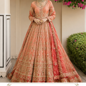 Gulbahar Peach Royale Lehenga by Maharani Designer Boutique Make every celebration unforgettable with the Gulbahar Peach Royale Lehenga, an elegant designer-inspired Indian ensemble created for women who love sophisticated colours, intricate embroidery and timeless bridal fashion. Presented by Maharani Designer Boutique, this exquisite peach-toned lehenga combines a soft, feminine colour palette with elaborate gold embroidery to create a luxurious outfit for weddings, receptions, engagements, sangeet celebrations and other grand occasions. The ensemble features a beautifully embellished peach blouse, a voluminous flared lehenga skirt and a coordinated peach dupatta. The entire outfit is enriched with detailed gold-toned ornamental embroidery, creating a graceful balance between traditional Indian craftsmanship and contemporary bridal styling. The soft peach base gives the outfit a refined and elegant character, while the extensive gold work adds richness and visual depth. The result is a sophisticated alternative to conventional red bridal wear, making this lehenga an excellent choice for brides, bridesmaids and women looking for a statement wedding outfit. The lehenga skirt is the centrepiece of the design. Its flowing silhouette is covered with vertical embroidered detailing that visually elongates the form. Toward the lower portion, the embroidery becomes increasingly elaborate, leading into multiple decorative borders and a scalloped embellished hem. The matching blouse features an elegant rounded neckline framed with detailed embroidery. The sleeves are also decorated with ornate work, creating a cohesive look from neckline to cuffs. A matching dupatta completes the ensemble with a beautifully decorated border and scattered motifs. Whether worn as a bridal lehenga, reception lehenga or luxury wedding outfit, the Gulbahar Peach Royale Lehenga offers an elegant expression of Indian occasion wear. Soft Peach Elegance The first impression of the Gulbahar Lehenga comes from its beautiful peach colour. Peach is a versatile occasion-wear shade that offers the warmth of traditional festive colours while maintaining a soft and contemporary appearance. It creates a delicate foundation for the gold embroidery and allows the intricate detailing to remain prominent without making the outfit appear overly heavy. The colour is especially suited to women who want something different from classic red, maroon or deep burgundy bridal outfits. The peach-and-gold combination works beautifully for daytime celebrations, evening receptions and indoor wedding ceremonies. For a daytime event, the soft peach tone can be styled with delicate jewellery and natural makeup. For an evening celebration, statement gold jewellery and more defined makeup can transform the same outfit into a glamorous ensemble. Heavily Embroidered Lehenga Skirt The flared lehenga skirt is designed to create a graceful and dramatic silhouette. Its expansive shape allows the elaborate embroidery to remain visible across the entire garment. The skirt features repeated vertical decorative patterns that flow from the waist toward the lower hem. These patterns create a sense of continuity and give the skirt an elongated visual appearance. The embroidery includes floral and ornamental-inspired elements arranged in a structured composition. The upper and middle sections feature detailed motifs, while the lower section becomes progressively richer with multiple layers of decorative borders. This gradual increase in embroidery creates a beautiful transition toward the hemline. The broad embroidered hem provides a strong finishing detail and gives the skirt a traditional couture-inspired appearance. Intricate Gold-Toned Embroidery The gold-toned embroidery is one of the most distinctive features of this designer lehenga. It contrasts beautifully against the peach base and creates a luxurious surface texture. The embroidery is distributed across the blouse, skirt and dupatta rather than being concentrated in one area. This coordinated approach gives the complete outfit a polished and balanced appearance. Gold detailing can catch warm ambient light beautifully, making the outfit especially suitable for wedding halls, reception venues and evening celebrations. The elaborate decorative work also photographs beautifully, adding texture and dimension to full-length bridal portraits. Elegant Embroidered Blouse The blouse has been designed to complement the elaborate lehenga rather than compete with it. Its neckline is framed with intricate embroidery, creating a natural focal point around the face. The front features delicate ornamental detailing that transitions naturally into the heavily decorated skirt. The sleeves continue the same design language, with embroidery placed around the upper and lower portions. The result is a blouse that feels rich and festive while maintaining an elegant silhouette. The blouse can be paired with statement earrings, a choker or a layered necklace depending on the occasion. Beautiful Neckline Design The neckline is an important feature of the blouse because it provides a natural frame for bridal jewellery. The rounded neckline is surrounded by ornate embroidery that adds definition and sophistication. A statement choker can be worn close to the neckline for a traditional bridal appearance. Alternatively, a longer necklace can be used to create a more elongated jewellery profile. For brides who prefer a minimalist approach, the detailed neckline itself provides enough visual interest to be paired with statement earrings alone. Embellished Sleeves The sleeves are carefully coordinated with the rest of the outfit. Detailed embroidery around the cuffs adds refinement and provides a beautiful connection to the bangles and jewellery worn on the wrists. The sleeve design maintains the sophisticated character of the outfit while offering enough coverage for traditional wedding styling. Gold bangles, peach-toned bangles or a combination of metallic accessories can be used to complement the sleeve borders. Grand Multi-Border Hem One of the most eye-catching elements of the lehenga is its ornate lower border. Multiple horizontal embroidered bands create a rich frame around the skirt. The borders incorporate floral, paisley-inspired and ornamental patterns that echo the embroidery used throughout the garment. The final scalloped edge gives the skirt a soft yet elaborate finish. When the lehenga is spread for photographs, the border becomes an especially striking detail. It can also enhance the visual appearance of the skirt while walking or during bridal portraits. Matching Peach Dupatta The coordinated dupatta completes the ensemble. It features the same peach colour as the lehenga and blouse, creating a seamless three-piece look. The dupatta is decorated with a prominent embroidered border and scattered motifs. The border gives definition to the lightweight-looking fabric and makes the drape appear more luxurious. The dupatta can be styled in multiple ways according to the occasion. For a traditional bridal look, it can be draped over the head. For a reception, it can be placed over one shoulder. For a more contemporary appearance, it can be arranged across one arm while keeping the embroidered blouse fully visible. Ornate Dupatta Border The dupatta border provides a beautiful finishing detail. Its elaborate embroidery visually connects the dupatta with the borders of the lehenga. This repetition ensures that the outfit looks coordinated from every angle. When the dupatta is draped over the shoulder, its border creates a vertical decorative line that complements the long silhouette of the outfit. When draped over the head, the border can frame the face and enhance traditional bridal styling. Perfect for Weddings The Gulbahar Peach Royale Lehenga is an excellent choice for women attending important wedding celebrations. Its sophisticated peach colour makes it particularly suitable for brides who want a softer bridal palette, as well as bridesmaids and close family members. The outfit can be considered for: Wedding ceremonies Bridal receptions Engagement parties Sangeet celebrations Mehndi functions Wedding receptions Family celebrations Pre-wedding photography Festive events Formal Indian celebrations Its elaborate embroidery gives it enough grandeur for major occasions while its peach base keeps the overall appearance elegant. Bridal Styling Inspiration For a bride choosing this peach bridal lehenga, traditional gold jewellery can create a regal appearance. Consider styling the outfit with: Gold choker Long necklace Statement earrings Maang tikka Bangles Rings Kamarbandh Embellished footwear A traditional hairstyle such as a low bun decorated with flowers can enhance the bridal character. For a modern bridal look, soft waves or a sleek hairstyle can be paired with statement earrings and a single necklace. Jewellery Pairing Gold Jewellery Gold jewellery is a natural match for the gold-toned embroidery. It reinforces the warm colour palette and creates a cohesive traditional look. Kundan-Inspired Jewellery Kundan-inspired jewellery can introduce additional richness while maintaining the traditional Indian aesthetic. Pearl Accents Pearl detailing can soften the overall appearance and complement the delicate peach base. Statement Earrings Large earrings can be particularly effective when the blouse neckline is already heavily decorated. Choker Necklace A choker can beautifully frame the embroidered neckline. Maang Tikka A maang tikka adds a traditional bridal finishing touch. Styling for a Wedding Reception For a reception, the Gulbahar Lehenga can be styled with glamorous but balanced accessories. Choose statement earrings, a delicate necklace and an embellished clutch. Allow the dupatta to fall naturally over one shoulder so the detailed blouse remains visible. A sleek hairstyle or soft waves can create a modern contrast against the traditional embroidery. Metallic heels can provide additional height while complementing the gold detailing. Styling for Sangeet For a sangeet, the outfit can be styled with lighter jewellery and a more relaxed dupatta arrangement. Choose statement earrings and layered bangles. A contemporary hairstyle can give the traditional silhouette a youthful character. The flared skirt is particularly attractive for movement and photography, making it a strong choice for celebratory events. Styling for Engagement For an engagement ceremony, pair the lehenga with refined jewellery rather than excessive layering. A statement choker, earrings and delicate bangles can provide enough glamour. Soft makeup and a polished hairstyle can enhance the peach colour. The result is elegant, feminine and sophisticated. Styling for Mehndi The peach shade can also be styled beautifully for a mehndi celebration. Introduce green, pink or multicoloured jewellery to create a more festive appearance. Floral accessories can add a youthful touch. For daytime events, softer makeup and minimal jewellery can allow the embroidery to remain the central feature. Contemporary Indian Fashion The Gulbahar Peach Royale Lehenga combines classic Indian design elements with a modern colour direction. Traditional embroidery, a full flared silhouette and an ornate dupatta provide the cultural character expected from Indian occasion wear. The peach palette gives the ensemble a contemporary feel. This combination makes the outfit suitable for women who appreciate heritage-inspired fashion but prefer softer and more modern colour choices. Ideal for Brides Who Want Something Different Not every bride wants a traditional red lehenga. Peach offers an elegant alternative that remains festive while feeling fresh. The Gulbahar Lehenga allows the bride to retain the grandeur of heavy embroidery while moving away from conventional bridal colour palettes. It can be especially appealing for: Day weddings Pastel-themed weddings Garden weddings Destination celebrations Reception ceremonies Engagement functions Modern traditional weddings The colour also pairs beautifully with neutral, gold and pastel wedding décor. Bridal Photography The detailed embroidery makes this lehenga particularly suitable for professional photography. The vertical embroidery creates visual movement throughout the skirt, while the broad hem provides a strong lower frame. The dupatta can be spread or draped naturally to create additional depth in photographs. For close-up portraits, the embellished neckline and jewellery create an elegant frame around the face. For full-length photographs, the flared silhouette and ornate hem become the primary visual focus. Hair & Makeup Suggestions Classic Bridal Bun A low bun with traditional floral decoration works beautifully with the peach-and-gold colour palette. Soft Curls Loose curls create a romantic and contemporary appearance. Sleek Low Ponytail For a modern reception look, a sleek ponytail can create a sophisticated contrast. Traditional Braided Style A decorated braid can enhance the Indian bridal character. For makeup, warm neutral eyes, glowing skin and peach or rose-toned lips can complement the outfit. For evening celebrations, stronger eye makeup and a deeper lip colour can provide additional drama. Footwear Choose footwear that complements both the colour and embroidery. Recommended options include: Gold embellished heels Champagne heels Peach sandals Metallic footwear Embroidered juttis Traditional mojaris Because the lehenga has a long, flowing silhouette, footwear height should be considered when finalizing the outfit length. Handbag & Clutch An embellished clutch can complete the ensemble. Gold, champagne, peach or neutral shades can work particularly well. For weddings, a compact embroidered potli can create a traditional finish. For receptions, a structured metallic clutch can give the outfit a contemporary appearance. Why Choose the Gulbahar Royale Lehenga? The Gulbahar Lehenga brings together several elements that make it a strong occasion-wear choice: Elegant Peach Base: A soft and sophisticated alternative to conventional bridal colours. Gold Embroidery: Elaborate detailing creates a luxurious visual appearance. Flared Silhouette: Adds graceful movement and bridal drama. Embroidered Blouse: Coordinates beautifully with the skirt. Decorated Dupatta: Completes the ensemble with an ornate border. Versatile Styling: Suitable for weddings, receptions, engagements and festive celebrations. Statement Appearance: Designed to make an impression while maintaining refined elegance. Maharani Designer Boutique Maharani Designer Boutique presents Indian occasion wear with an emphasis on elegant silhouettes, detailed embellishment and celebration-ready styling. The Gulbahar Peach Royale Lehenga reflects this aesthetic through its delicate peach colour, extensive gold-toned embroidery and coordinated three-piece design. It is created for women who want their occasion wear to feel special, sophisticated and distinctly Indian. Whether selected for a bridal celebration, reception, engagement or grand wedding function, the ensemble offers a refined interpretation of traditional lehenga fashion. Product Details Product Name: Gulbahar Peach Royale Lehenga Brand: Maharani Designer Boutique Category: Designer Lehenga / Bridal Lehenga Colour: Peach Embroidery: Gold-toned ornamental and floral-inspired embroidery Blouse: Embroidered peach blouse with decorated neckline and sleeves Lehenga: Flared peach skirt with extensive embroidery and multi-layered decorative borders Dupatta: Matching peach dupatta with embroidered border and scattered motifs Style: Indian Traditional / Designer Occasion Wear Ideal For: Weddings, Receptions, Engagements, Sangeet, Mehndi, Festive Events and Formal Celebrations Note: Exact fabric composition, lining, embroidery technique, measurements, blouse construction and customization details should be confirmed with Maharani Designer Boutique before purchase, as these specifications cannot be determined with certainty from the product image alone. Care & Storage Due to the detailed embroidery and embellishment, careful handling is recommended. Store the lehenga in a clean, breathable garment bag away from direct sunlight and moisture. Avoid placing heavy objects on the embroidered areas. Keep perfume, cosmetics, oils and other liquids away from the garment. When transporting the lehenga, fold it carefully and protect the embroidered surfaces from excessive friction. The dupatta should also be stored carefully to prevent its decorative border from becoming crushed. Follow the garment's actual care label for cleaning instructions. Depending on the final fabric and embellishment, professional cleaning may be appropriate. After wearing the outfit, allow it to air appropriately before long-term storage and ensure it is completely dry before packing. peach bridal lehenga, peach bridal lehenga for wedding, peach wedding lehenga, peach wedding lehenga for bride, peach lehenga for bride, peach designer lehenga, peach bridal lehenga online, peach lehenga online, peach and gold lehenga, peach and gold bridal lehenga, peach gold wedding lehenga, gold embroidered peach lehenga, peach embroidered lehenga, heavily embroidered peach lehenga, heavy work peach lehenga, >designer bridal lehenga, designer wedding lehenga, bridal lehenga for women, bridal lehenga online, bridal lehenga India, Indian bridal lehenga, Indian wedding lehenga, traditional bridal lehenga, modern bridal lehenga, pastel bridal lehenga, pastel peach lehenga, pastel wedding lehenga, pastel bridal wear, luxury bridal lehenga, luxury wedding lehenga, designer bridal wear, designer bridal lehenga, designer wedding lehenga, bridal lehenga for women, bridal lehenga online, bridal lehenga India, Indian bridal lehenga, Indian wedding lehenga, traditional bridal lehenga, modern bridal lehenga, pastel bridal lehenga, pastel peach lehenga, pastel wedding lehenga, pastel bridal wear, luxury bridal lehenga, luxury wedding lehenga, designer bridal wear,