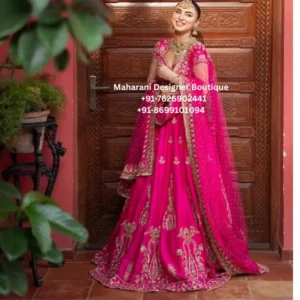 Rani Pink Royal Embroidered Bridal Lehenga Choli Step into timeless elegance with the Rani Pink Royal Embroidered Bridal Lehenga Choli, a statement Indian ethnic ensemble created for weddings, receptions, festive celebrations and grand occasions. The vibrant hot pink base paired with intricate golden embroidery gives this lehenga a luxurious and celebratory appearance. The beautifully flared lehenga features elaborate floral and ornamental embroidery arranged across the skirt, creating a rich and graceful look. The detailed embroidered hem adds definition to the expansive flare, while the repeated motifs throughout the skirt enhance its traditional bridal appeal. The matching pink choli features an elegant neckline and delicate embellishment, complemented by sheer sleeves that add a soft and sophisticated touch. The fitted blouse balances the voluminous lehenga beautifully and creates a flattering overall silhouette. Completing the ensemble is a stunning sheer pink dupatta adorned with delicate embellishments and a heavily embroidered golden border. Draped over the shoulder, the dupatta adds movement, elegance and a beautiful finishing touch to the outfit. The vibrant pink and antique-gold combination makes this ensemble especially suitable for brides, bridesmaids and wedding guests who want a traditional Indian look with a glamorous contemporary feel. Style Highlights Rich hot pink/fuchsia color Flared bridal lehenga silhouette Intricate golden embroidery Floral and traditional ornamental motifs Embellished blouse Elegant sheer sleeves Matching sheer dupatta Heavy embroidered dupatta border Statement festive appearance Suitable for wedding and celebration wear Perfect For Bridal wedding ceremonies Reception parties Engagement celebrations Mehndi functions Sangeet ceremonies Bridesmaid outfits Wedding guest wear Diwali celebrations Festive occasions Traditional family functions Luxury evening events Indian wedding photography Styling Suggestions Style this vibrant pink lehenga with traditional gold jewellery, statement earrings, a maang tikka and embellished footwear for a classic bridal appearance. A sleek bun decorated with flowers can enhance the traditional aesthetic, while soft waves can create a more contemporary wedding look. For a bridesmaid or wedding guest appearance, pair the outfit with lighter jewellery and a compact embellished clutch. Gold, champagne and antique-finish accessories complement the pink-and-gold color combination beautifully. hot pink bridal lehenga, pink bridal lehenga choli, pink lehenga choli, embroidered bridal lehenga, designer bridal lehenga, wedding lehenga for women, pink wedding lehenga, bridal lehenga online, Indian bridal lehenga, fuchsia pink lehenga, embroidered lehenga choli, wedding guest lehenga, reception lehenga, engagement lehenga, mehndi lehenga, sangeet lehenga, bridesmaid lehenga, festive lehenga for women, traditional Indian lehenga, pink wedding outfit, bridal ethnic wear, luxury bridal lehenga, embellished lehenga choli, Indian wedding outfit