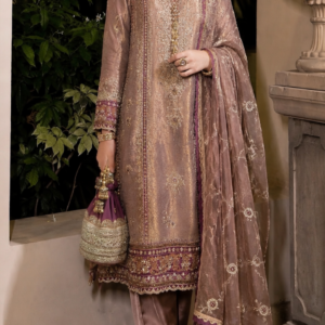 Gul-e-Zareen – Dusty Rose Designer Punjabi Suit Discover the refined beauty of traditional Indian occasion wear with Gul-e-Zareen, an elegant dusty rose Punjabi suit designed for women who appreciate sophisticated colours, intricate embroidery, graceful silhouettes, and timeless craftsmanship. Created by Maharani Designer Boutique, this ensemble brings together a soft dusty rose base with delicate gold-toned embroidery and rich burgundy accents. The combination creates an understated yet luxurious appearance that is perfect for weddings, festive celebrations, formal gatherings, engagement ceremonies, family functions, and elegant evening occasions. The ensemble features a beautifully embroidered straight-cut kameez, matching trousers, and a lightweight sheer dupatta. Every component has been carefully coordinated to create a polished head-to-toe look. The kameez showcases detailed embroidery throughout the front, delicate motifs across the body, ornate vertical borders, and an elaborate lower hem. The sleeves continue the embroidery theme with decorative cuffs that add definition to the silhouette. The matching trousers provide a clean and elegant foundation beneath the longer kameez, while the sheer dupatta introduces softness and movement. Its delicate embroidered motifs, ornate border, and contrasting burgundy edging add an especially graceful finishing touch. The dusty rose and muted gold palette gives the outfit a sophisticated personality. Rather than relying on an extremely bright colour, the design uses subtle tones to create an elegant, mature, and versatile occasion-wear look. Gul-e-Zareen is ideal for the modern woman who wants traditional Indian clothing with a polished contemporary character. The Elegance of Dusty Rose Dusty rose is one of the most versatile colours in contemporary Indian fashion. Its soft, muted character creates a sophisticated alternative to brighter pinks while retaining the feminine appeal associated with rose tones. In this ensemble, dusty rose provides a beautiful foundation for the gold embroidery. The subtle base colour allows the intricate detailing to remain visible without making the outfit appear overly heavy. Burgundy accents introduce depth and create an elegant contrast against the softer pink-toned base. This combination works beautifully for daytime celebrations as well as evening occasions. Under natural daylight, the dusty rose colour creates a soft and graceful appearance. Under warm evening lighting, the gold embroidery adds richness and dimension. The colour also makes the outfit easy to accessorise. Gold jewellery enhances the warm embroidery, while pearls and muted gemstone tones can create a softer appearance. For women who prefer elegant pastel-inspired Indian wear, this dusty rose Punjabi suit offers a refined choice for special occasions. Dusty Rose Embroidered Anarkali Lehenga, Sage Green Designer Sharara Suit, Royal Rose Gold Embroidered Punjabi Suit, Royal Dusty Mauve Hand Embroidered Salwar Suit, MDB 027210118 Intricate Embroidered Kameez The kameez is the central element of Gul-e-Zareen. Its straight silhouette provides a graceful and sophisticated shape while allowing the embroidery to remain the primary visual focus. The front features intricate gold-toned embroidery arranged in a vertically elongated composition. The neckline is framed with delicate decorative detailing that continues downward into the central embroidered panel. This creates an elegant focal point around the face and upper body. The body of the kameez features small floral and ornamental motifs distributed across the dusty rose fabric. These scattered details add visual interest while allowing enough of the base colour to remain visible. The overall embroidery has a refined appearance rather than looking excessively dense. This makes the outfit suitable for women who prefer detailed craftsmanship with an elegant and wearable finish. Beautifully Detailed Neckline The neckline adds an important element of sophistication to the design. It features a fine embroidered outline that complements the central front panel. The detailing around the neckline creates a natural frame for jewellery. A delicate choker can be worn to enhance the neckline, while statement earrings can create a more contemporary styling option. For a traditional appearance, the neckline can be paired with a coordinated necklace, jhumkas, and bangles. For a modern formal look, large earrings can be worn without a necklace, allowing the embroidery to remain the centre of attention. Elegant Front Embroidery The front panel of the kameez showcases carefully arranged embroidery that extends vertically down the garment. The use of vertical detailing creates an elongated visual effect and gives the straight silhouette a graceful appearance. The central motif is complemented by delicate surrounding patterns. Smaller motifs appear throughout the front, creating continuity between the neckline and hem. The embroidery combines warm gold tones with subtle burgundy accents, creating depth against the dusty rose base. This combination gives the outfit a luxurious yet understated character. Detailed Full Sleeves The full sleeves provide a sophisticated finish. They feature delicate embroidery across the length, with additional detailing around the cuffs. The cuffs are particularly decorative and introduce a stronger embroidered border at the wrists. This creates a beautiful finishing detail when the hands are accessorised with bangles or bracelets. The long sleeves also make the ensemble suitable for formal evening functions and cooler-season celebrations. The combination of detailed sleeves and a straight-cut kameez gives the outfit a polished and elegant silhouette. Ornate Kameez Hem The lower hem of the kameez features a rich embroidered border. Multiple decorative layers create a defined finish around the bottom of the garment. The border includes floral and ornamental-inspired detailing with gold-toned embroidery and burgundy accents. This heavier lower border creates visual balance with the embroidery on the neckline and sleeves. It also adds structure to the straight silhouette. When paired with the matching trousers, the detailed hem creates a sophisticated transition between the upper and lower portions of the outfit. Matching Trouser The ensemble is completed with matching trousers in a coordinating dusty rose tone. The trousers provide a clean foundation beneath the longer kameez. Their streamlined appearance allows the detailed upper portion of the outfit and the dupatta to remain the focus. The trouser hem is finished with subtle decorative detailing that complements the kameez. This coordinated approach gives the entire outfit a cohesive appearance. The trousers can also make the ensemble practical for movement while maintaining the elegance expected from occasion wear. Sheer Embroidered Dupatta The dupatta is one of the most beautiful components of Gul-e-Zareen. Its lightweight, sheer appearance creates a soft layer over the outfit. The dusty rose tone maintains the overall colour harmony, while delicate embroidered motifs are scattered across the fabric. The motifs include small floral and ornamental-inspired patterns that coordinate with the embroidery on the kameez. The border is particularly striking. It features elaborate gold-toned embroidery combined with a contrasting burgundy edge. This contrast gives the dupatta a defined and luxurious finish. The dupatta can be styled traditionally over both shoulders, placed over one shoulder, or arranged across the arms for a more formal appearance. It can also be draped over the head for traditional wedding and ceremonial occasions. Burgundy and Gold Accents The use of burgundy accents adds depth to the soft dusty rose colour. Rather than creating a completely monochromatic outfit, the burgundy details provide contrast around important design areas. The accents appear in the embroidery, borders, and dupatta finishing. Gold embroidery sits beautifully between the two colours, creating a cohesive visual connection. This combination is particularly attractive for women who enjoy soft colours but still want their outfit to have a rich and luxurious character. Perfect for Weddings Gul-e-Zareen is an excellent option for women looking for sophisticated wedding attire. Its refined colour palette and intricate embroidery make it suitable for several wedding-related events. Wear it for: Engagement ceremonies Mehendi celebrations Sangeet functions Wedding receptions Family weddings Pre-wedding gatherings Wedding guest occasions Festive dinners Destination weddings Cultural celebrations Anniversary events Formal family functions The outfit can be styled differently for each occasion by changing the jewellery, hairstyle, makeup, and dupatta drape. Elegant Engagement Wear For an engagement ceremony, this dusty rose suit can create a graceful and sophisticated appearance. Pair it with statement gold earrings, a delicate choker, and a polished hairstyle. A soft pink or rose-toned lip can complement the colour palette. For a more contemporary look, choose oversized earrings and leave the neck free. The embroidery around the neckline will then provide enough detail to frame the face. The soft colour also photographs beautifully, making the outfit particularly suitable for engagement portraits. Sophisticated Mehendi Outfit The dusty rose shade provides a softer alternative to traditional bright mehendi colours. For a daytime mehendi celebration, style the outfit with floral jewellery, delicate bangles, and soft waves. For an evening mehendi event, gold jewellery and a statement clutch can create a more luxurious appearance. The lightweight dupatta can be arranged over one shoulder to allow comfortable movement while keeping the embroidered border visible. Sangeet Styling The straight silhouette gives the outfit a polished appearance for sangeet celebrations. For a contemporary sangeet look, wear the dupatta over one shoulder and pair it with statement earrings. A sleek bun or soft waves can complete the look. For a more traditional styling direction, add a choker, bangles, and a maang tikka. The dusty rose and gold palette will also work beautifully under event lighting. Wedding Guest Outfit Gul-e-Zareen is particularly suitable for wedding guests who want to look elegant without appearing excessively bridal. The soft colour keeps the appearance refined, while the embroidery provides enough richness for a formal celebration. Pair it with: Gold earrings A delicate clutch Metallic footwear Minimal bangles Soft makeup A polished hairstyle For a close family wedding, the jewellery can be made more elaborate. For a formal reception, statement earrings and a structured clutch can create a sophisticated appearance. Festive Indian Wear The versatility of this Punjabi suit extends beyond weddings. It can be worn for Diwali celebrations, family gatherings, festive dinners, cultural events, anniversary celebrations, and special occasions. For Diwali, pair the outfit with gold jewellery and a metallic clutch. For a family celebration, choose pearl or delicate gold accessories. For an evening event, add statement earrings and a more defined makeup look. The dusty rose colour gives the ensemble a timeless character that can work across different festive settings. Jewellery Styling The gold embroidery naturally complements traditional Indian jewellery. For a classic look, choose a gold-toned choker with matching earrings. Kundan-inspired jewellery can add a regal touch. Pearls can create a softer and more sophisticated appearance. For a contemporary look, choose oversized statement earrings and skip the necklace. Bangles can be coordinated with the burgundy and gold detailing. A statement ring can provide an additional finishing touch. The versatility of the embroidery allows the outfit to work with both traditional and modern jewellery. Hairstyle Suggestions A sleek low bun creates a polished and sophisticated appearance. For traditional celebrations, a centre-parted bun decorated with flowers can complement the outfit beautifully. For engagement or reception styling, soft waves create a romantic and contemporary look. A polished side-parted hairstyle can also work well for formal occasions. If the dupatta is placed over the head, a neat bun provides a clean foundation. Makeup Suggestions The dusty rose colour pairs naturally with warm and soft makeup tones. For daytime events, choose luminous skin, softly defined eyes, natural blush, and a nude-pink or peach lip. For evening celebrations, add gold or champagne shimmer to the eyes and stronger eyeliner. Rose, mauve, peach, coral, and muted berry lip colours can all complement the outfit. The goal is to maintain balance between the delicate colour palette and the detailed embroidery. Photography-Friendly Design Gul-e-Zareen offers numerous details that work beautifully in photographs. The embroidered neckline creates a strong close-up focal point. The vertical front embroidery creates an elegant visual line. The detailed sleeves provide texture for portrait photographs. The embroidered hem creates definition around the lower silhouette. The sheer dupatta adds movement and softness. The dusty rose, gold, and burgundy colour combination also works beautifully against heritage architecture, neutral interiors, gardens, and luxury event settings. This makes the outfit suitable for engagement photographs, wedding guest portraits, family pictures, and festive photoshoots. Traditional Yet Contemporary The outfit successfully combines traditional Indian craftsmanship with contemporary styling. The Punjabi suit silhouette remains rooted in Indian fashion, while the muted colour palette gives it a modern personality. The delicate embroidery creates traditional richness without making the ensemble appear excessively heavy. The sheer dupatta adds softness and movement. This balance makes Gul-e-Zareen suitable for women who want Indian occasion wear that feels elegant and current. Destination Wedding Style The sophisticated colour palette makes this ensemble a beautiful choice for destination weddings. It can complement palace venues, luxury hotels, heritage properties, gardens, and resort settings. For daytime destination events, pair it with delicate jewellery and soft makeup. For evening celebrations, choose statement gold jewellery and a metallic clutch. The sheer dupatta can create beautiful movement in outdoor photographs. Designer Indian Wear for Global Celebrations Indian weddings and cultural events are celebrated across the world, and elegant Punjabi suits remain a popular choice for women attending these occasions. Gul-e-Zareen can be styled for Indian weddings and celebrations in Canada, the USA, the UK, Australia, New Zealand, and other international destinations. Its sophisticated colour palette works particularly well for multicultural celebrations where traditional Indian clothing meets contemporary fashion. Maharani Designer Boutique offers PAN India and worldwide shipping for customers seeking designer Indian occasion wear. Custom-Made Designer Experience At Maharani Designer Boutique, selected designs may be customised or made to measure according to individual requirements. Customers can discuss measurements, fitting preferences, neckline details, sleeve requirements, dupatta styling, and other possible customisation options depending on the selected design. If the outfit is required for a particular wedding or event, customers are encouraged to share the event date before confirming the order. Production timelines can vary depending on embroidery, construction, customisation, and order requirements. A Versatile Addition to Your Occasion-Wear Wardrobe A beautifully crafted Punjabi suit can become one of the most versatile pieces in a woman's occasion-wear wardrobe. The same outfit can create different appearances depending on accessories and styling. With traditional jewellery, it becomes a classic Indian festive look. With statement earrings and minimal accessories, it becomes contemporary formal wear. With floral jewellery, it can become a soft mehendi outfit. With a statement choker and glamorous makeup, it can become an elegant reception ensemble. This versatility makes Gul-e-Zareen a practical yet luxurious choice for women who want more than a single-occasion outfit. Care and Storage Because the ensemble features delicate embroidery and a lightweight dupatta, careful handling is recommended. Store the outfit in a clean, dry garment bag when it is not being worn. Avoid placing heavy items directly over embroidered sections. Fold the dupatta carefully to help protect its embroidery and border. Professional cleaning is recommended for embellished occasion wear. The exact cleaning method should be selected according to the actual fabric and embroidery used in the finished garment. Always follow the garment-specific care instructions supplied with the outfit. Why Choose Gul-e-Zareen? Choose Gul-e-Zareen if you are looking for: A dusty rose designer Punjabi suit A sophisticated Indian occasion outfit Gold embroidered Punjabi wear A wedding guest suit An engagement outfit A mehendi suit A sangeet ensemble A festive Punjabi suit A designer suit with dupatta A pastel-inspired Indian outfit A luxury ethnic wear ensemble Custom-made Indian occasion wear Premium designer clothing The Beauty of Understated Luxury Luxury does not always have to be defined by extremely bright colours or heavy embellishment. Sometimes, the most elegant designs rely on carefully selected colours and refined detailing. Gul-e-Zareen reflects this philosophy. The dusty rose base creates softness. Gold embroidery adds richness. Burgundy accents create depth. The sheer dupatta introduces movement. The ornate borders provide structure. Together, these details create a sophisticated form of understated luxury. A Timeless Indian Fashion Choice Traditional Punjabi suits continue to remain relevant because of their versatility and cultural character. They can be styled for weddings, festivals, family celebrations, formal gatherings, and everyday special occasions. Gul-e-Zareen takes the familiar Punjabi suit silhouette and gives it a refined designer interpretation through delicate embroidery and a sophisticated colour palette. The result is an outfit that feels traditional without looking dated. It is feminine, elegant, graceful, and versatile. Final Look Gul-e-Zareen is a celebration of soft colour, intricate embroidery, graceful tailoring, and timeless Indian elegance. The dusty rose kameez creates a sophisticated foundation, while delicate gold-toned embroidery adds richness throughout the neckline, front, sleeves, and hem. The coordinating trousers provide a streamlined lower silhouette, while the sheer dupatta adds softness and movement. Its elaborate gold border and burgundy accents create a luxurious finishing detail, bringing together the entire colour story. Whether you are attending an engagement, mehendi, sangeet, wedding reception, festive celebration, family function, or formal event, Gul-e-Zareen offers a sophisticated way to embrace designer Punjabi fashion. Discover elegant Indian occasion wear from Maharani Designer Boutique, where traditional craftsmanship meets contemporary styling. For current availability, pricing, measurements, fabric specifications, customisation, production timelines, and shipping information, contact Maharani Designer Boutique before placing your order. Product Highlights Dusty rose designer Punjabi suit Soft rose-toned base Intricate gold-toned embroidery Burgundy embroidery accents Detailed embroidered neckline Elaborate front embroidery Full embroidered sleeves Decorative sleeve cuffs Richly embroidered kameez hem Matching dusty rose trousers Sheer embroidered dupatta Ornate gold dupatta border Burgundy dupatta edging Scattered dupatta motifs Traditional Punjabi suit silhouette Contemporary colour palette Ideal for weddings Perfect for engagement ceremonies Suitable for mehendi and sangeet Elegant festive wear Sophisticated wedding guest outfit Customisation may be available Made-to-measure options may be available PAN India and worldwide shipping Dusty rose Punjabi suit, dusty rose designer suit, dusty pink Punjabi suit, dusty rose suit online, designer Punjabi suit, designer Punjabi suits online, embroidered Punjabi suit, gold embroidered Punjabi suit, dusty pink embroidered suit, Punjabi suit for wedding, wedding Punjabi suit, Punjabi wedding outfit, wedding guest Punjabi suit, engagement Punjabi suit, mehendi Punjabi suit, Punjabi Salwar Suits sangeet Punjabi suit, festive Punjabi suit, designer suit with dupatta, embroidered suit with dupatta, pastel Punjabi suit, pastel designer suit, luxury Punjabi suit, Indian ethnic wear, designer ethnic wear, Punjabi suits online India, Punjabi suits online Canada, Punjabi suits online USA, Punjabi suit boutique, designer boutique suits Jalandhar, Maharani Designer Boutique, Indian designer wear, premium Indian clothing, custom made Punjabi suits.