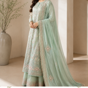 Noor-e-Sahar – Elegant Pastel Mint Green Designer Suit Introducing Noor-e-Sahar, an exquisite pastel mint green designer suit from Maharani Designer Boutique, created for women who love sophisticated Indian and Pakistani ethnic fashion with a soft, graceful aesthetic. This beautifully coordinated ensemble combines a delicate mint green palette with intricate floral embroidery, an elegant straight-cut silhouette, matching trousers, and a statement flowing dupatta finished with an ornate embroidered border. Designed with an emphasis on refined detailing, graceful proportions, and timeless femininity, Noor-e-Sahar is a perfect choice for weddings, festive celebrations, engagement functions, mehendi ceremonies, family gatherings, dinner parties, festive events, and sophisticated daytime occasions. The soft pastel mint colour gives the outfit an instantly fresh and elegant appearance. Delicate blush pink, ivory, and subtle metallic embroidery adds dimension to the fabric while maintaining a refined and understated character. The result is a luxurious ethnic ensemble that feels graceful rather than overwhelming. The long embroidered kurta is complemented by matching trousers and a generously draped dupatta. The entire outfit creates a fluid silhouette that looks beautiful from every angle. The detailed borders around the neckline, front panel, sleeves, trouser hem, and dupatta add structure and definition to the pastel colour palette. Whether you are searching for a pastel green Pakistani suit, mint green designer suit, embroidered Punjabi suit, wedding guest outfit, or luxury ethnic wear for women, Noor-e-Sahar offers a sophisticated option for your wardrobe. A Dreamy Pastel Mint Green Colour The defining characteristic of Noor-e-Sahar is its beautiful pastel mint green shade. Soft, refreshing, and sophisticated, mint green is an excellent choice for women who prefer elegant pastel tones instead of deeper traditional colours. The subtle colour creates a calm and luxurious appearance. It works beautifully for daytime celebrations, spring weddings, summer events, festive gatherings, and intimate family functions. The pastel base also provides the perfect canvas for the delicate embroidery. Instead of overpowering the fabric, the embroidery blends beautifully with the base while introducing soft touches of pink, ivory, gold, and complementary tones. This creates a sophisticated tonal effect. The colour can be styled with pearl jewellery for an elegant appearance or paired with gold accessories for a more traditional Indian look. Intricate Floral Embroidery Noor-e-Sahar features delicate floral embroidery throughout the ensemble. The embroidery is arranged thoughtfully across the front of the kurta, creating a graceful vertical effect. Floral motifs appear at different points across the fabric, creating visual balance. The detailed embroidery around the front panel gives the outfit a statement centre without making the design feel excessively heavy. The sleeves feature complementary detailing, while the lower hem carries an intricate floral border. The embroidery is further enhanced by delicate pastel accents. This combination creates a romantic and feminine appearance that works especially well for weddings and elegant festive occasions. The floral inspiration also makes the outfit ideal for spring and summer celebrations. Elegant Long Kurta The long kurta forms the central element of Noor-e-Sahar. Its elongated silhouette provides a sophisticated and flattering appearance. The design features a rounded neckline with a beautifully embroidered front panel. Vertical detailing from the neckline down the front creates a lengthening visual effect. The hem is finished with a richly embroidered border that gives the kurta a polished appearance. The sleeves are designed with an elegant length and feature detailed embroidery near the cuffs. This creates continuity throughout the outfit. The silhouette remains graceful and comfortable, making it suitable for occasions where you want to look dressed up while maintaining ease of movement. Statement Front Panel The front panel is one of the most noticeable elements of the design. Delicate floral motifs frame the neckline and continue down the centre. The embroidery creates a subtle architectural effect that gives the otherwise soft silhouette additional definition. The placement of the motifs ensures that the outfit looks refined even when the dupatta is draped over one shoulder. When the dupatta is opened fully, the detailed front embroidery becomes more visible. This makes the ensemble particularly attractive for photographs. Beautifully Embroidered Sleeves The sleeves continue the delicate design language of the kurta. Floral embroidery is placed across the sleeves with additional detailing around the cuffs. The embroidered cuffs create a beautiful finishing touch. They also provide an opportunity to accessorise with bangles or bracelets. For a traditional look, stack delicate bangles around the wrists. For a modern appearance, wear a single statement bracelet. The sleeve design allows the embroidery to remain visible even when the dupatta is draped across the body. Matching Mint Green Trousers The coordinating trousers complete the ensemble. Designed in the same pastel mint green colour, they create a seamless monochromatic appearance. The trousers feature delicate embroidery near the hem, providing balance with the embroidered border of the kurta. This creates a coordinated finish from top to bottom. The matching bottom also allows the dupatta to remain the main flowing element of the outfit. The silhouette is elegant and practical, making it appropriate for formal events as well as semi-formal celebrations. Flowing Statement Dupatta The dupatta is designed to provide an elegant finishing layer. Its soft mint green colour complements the kurta and trousers. The fabric appears light and flowing, allowing the dupatta to fall naturally around the body. The outer border is heavily embroidered, creating a beautiful frame. Delicate floral motifs are scattered across the dupatta. This combination of subtle all-over detailing and a statement border creates a sophisticated appearance. The dupatta can be styled in several ways. Drape it over one shoulder for a contemporary look. Carry it across both shoulders for a traditional silhouette. Allow it to fall freely on both sides for an elegant formal appearance. For wedding ceremonies, it can also be styled over the head. Ornate Dupatta Border The embroidered dupatta border adds richness to the entire outfit. The border combines delicate floral patterns with fine decorative detailing. Because the base colour remains soft, the border provides definition without making the outfit feel excessively heavy. When the dupatta is draped over the shoulder, the border frames the outfit beautifully. When it is allowed to fall freely, the embroidered edge creates a graceful vertical line. The border also complements the embroidery on the kurta and trouser hem, creating a cohesive three-piece ensemble. Perfect Pastel Wedding Outfit Noor-e-Sahar is an ideal choice for women looking for elegant pastel wedding wear. Pastel colours are particularly popular for daytime weddings and sophisticated pre-wedding functions. The mint green shade creates a fresh and contemporary appearance. For a wedding guest look, pair it with: Pearl earrings Delicate gold jewellery Embellished heels Soft curls Neutral clutch For a more traditional appearance, choose: Kundan jewellery Jhumkas Bangles Embellished juttis Soft updo Ideal for Mehendi Celebrations The pastel colour palette makes this suit particularly suitable for mehendi events. The floral embroidery complements the joyful atmosphere of a mehendi celebration. Style the outfit with floral jewellery for a youthful and festive appearance. You can add: Floral earrings Floral bracelets Fresh flowers in the hairstyle Pastel bangles Embellished sandals For a more sophisticated mehendi look, replace floral jewellery with pearl or gold accessories. Elegant Engagement Outfit Noor-e-Sahar can also be styled beautifully for an engagement ceremony. Its refined embroidery gives it a formal appearance without looking excessively bridal. Pair the suit with a statement necklace and matching earrings. A soft makeup palette will complement the pastel colour. Consider: Champagne eyeshadow Soft pink blush Defined eyeliner Highlighter Nude-pink lipstick This combination will enhance the feminine character of the outfit. Sophisticated Wedding Guest Look For wedding guests who prefer elegance over excessive embellishment, Noor-e-Sahar is an excellent choice. The pastel mint colour feels fresh and sophisticated. The embroidery adds enough detail to make the outfit suitable for formal celebrations. Style it with pearl earrings and a delicate bracelet for an understated appearance. Alternatively, choose traditional gold jewellery for a more festive look. Luxury Festive Wear The outfit can also be worn for festive celebrations. Its soft colour palette makes it particularly attractive for daytime festivities. For Diwali or other evening celebrations, add gold accessories and a metallic clutch. For daytime events, choose pearl jewellery and nude footwear. The outfit's versatility makes it suitable for multiple occasions rather than being limited to a single event. Pakistani Suit Inspired Silhouette Noor-e-Sahar draws inspiration from elegant Pakistani-style formal wear. The long straight kurta, embroidered trousers, and flowing dupatta create a classic silhouette associated with sophisticated South Asian fashion. The combination is especially appealing to women looking for Pakistani suits online, designer salwar suits, Punjabi ethnic wear, and luxury formal suits. The long silhouette provides graceful coverage while the embroidery adds a luxurious finish. Punjabi Suit Styling The outfit can also be styled as a sophisticated Punjabi suit. Choose traditional jhumkas, bangles, and embroidered Punjabi juttis. The pastel colour creates a softer interpretation of traditional Punjabi fashion. For a family function, pair it with a lightweight phulkari-inspired accessory. For a wedding, choose heavier jewellery. The same suit can therefore create different looks depending on styling. Styling with Jewellery Pearl Jewellery Pearls complement the soft mint green beautifully. Choose: Pearl choker Pearl earrings Pearl bracelet This creates a delicate and elegant appearance. Gold Jewellery Gold introduces warmth to the pastel colour. Choose: Gold jhumkas Delicate necklace Bangles Statement ring Kundan Jewellery Kundan jewellery gives the outfit a traditional wedding aesthetic. Choose a statement choker with matching earrings and a maang tikka. Hairstyle Ideas Soft waves are perfect for a romantic contemporary appearance. A low bun creates a sophisticated formal look. A centre-parted bun can be paired with a maang tikka. A side-swept hairstyle works beautifully with the long flowing dupatta. For mehendi celebrations, add fresh flowers or delicate floral accessories. The hairstyle can dramatically change the personality of the outfit. Makeup Guide The mint green palette works beautifully with soft, luminous makeup. Natural Day Look Use: Lightweight base Soft peach blush Brown eyeliner Natural lashes Nude-pink lips Wedding Guest Glam Choose: Soft gold eyeshadow Defined eyeliner Warm blush Highlighter Rose-toned lipstick Evening Glam For an evening celebration, use slightly deeper eye makeup and a muted berry lip. The key is to keep the makeup balanced so the delicate embroidery remains the focus. Footwear Recommendations Pair Noor-e-Sahar with: Nude heels Gold heels Embellished juttis Metallic sandals Pearl-detail footwear For daytime functions, embellished flats or juttis provide comfort. For formal evening events, heels can create a more elevated appearance. Perfect for Family Celebrations The outfit is versatile enough for family celebrations such as anniversaries, birthdays, religious gatherings, festive dinners, and special family functions. The embroidery provides an elevated appearance, while the pastel colour keeps the outfit approachable. This makes it a useful addition to an occasion-wear wardrobe. Seasonal Appeal Mint green is especially suitable for spring and summer. The pastel colour creates a fresh appearance in natural daylight. The floral embroidery also complements garden weddings, outdoor celebrations, and daytime functions. However, the detailed embroidery allows the outfit to transition into evening events when paired with statement jewellery and heels. Photography-Friendly Design Noor-e-Sahar photographs beautifully because of its combination of colour, embroidery, and flowing fabric. The pastel mint base creates a soft visual effect. The embroidered front panel provides a clear focal point. The long dupatta creates movement. The detailed border adds definition to photographs. For full-length photographs, allow the dupatta to fall naturally. For close-up portraits, highlight the neckline, embroidery, earrings, and sleeve details. For outdoor photographs, the mint green shade works beautifully against natural greenery and neutral architecture. Maharani Designer Boutique Maharani Designer Boutique creates sophisticated Indian ethnic wear designed for women who appreciate elegant craftsmanship, beautiful detailing, and timeless silhouettes. The boutique offers designer Punjabi suits, Pakistani-inspired suits, party wear suits, wedding outfits, lehengas, shararas, bridal wear, and custom-made ethnic clothing. Noor-e-Sahar reflects the boutique's focus on creating refined occasion wear that combines traditional South Asian aesthetics with contemporary styling. Custom-Made Options Depending on the design, customisation may be available. Customers may discuss: Measurements Fit Sleeve length Trouser length Kurta length Neckline preferences Dupatta styling Colour variations Embroidery modifications Customisation availability depends on the specific design and production requirements. For wedding orders, customers should provide their event date in advance so appropriate production timelines can be discussed. International Occasion Wear Noor-e-Sahar is suitable for women attending Indian and South Asian celebrations worldwide. Its elegant pastel colour makes it suitable for weddings and formal events in India, Canada, the USA, UK, Australia, and other international destinations. The timeless silhouette also makes it a practical choice for women who want premium Indian ethnic wear that can be styled across different occasions. Care Instructions Because this is an embellished occasion-wear ensemble, careful handling is recommended. Store the outfit in a clean, breathable garment bag. Avoid exposing the embroidery to rough surfaces. Keep the outfit away from excessive moisture. Do not place heavy objects over the embroidered sections. Fold the dupatta carefully to protect its embroidered border. For long-term storage, refold the garment periodically. Professional cleaning is recommended for heavily embroidered or delicate fabrics. Always follow the specific care instructions provided with the finished garment. Why Choose Noor-e-Sahar? Choose Noor-e-Sahar if you are searching for: Mint green designer suit Pastel green Pakistani suit Mint green Pakistani suit Pastel green Punjabi suit Mint green embroidered suit Designer Pakistani suit for women Pakistani suit for wedding Pastel suit for wedding Mint green wedding guest outfit Pastel wedding outfit Mint green party wear suit Pastel green party wear suit Embroidered Punjabi suit Designer Punjabi suit Pakistani style suit online Pakistani formal suit Mint green salwar suit Pastel green salwar suit Designer ethnic wear Luxury ethnic wear for women Wedding wear suit for women Engagement outfit Mehendi outfit Wedding guest suit Festive suit for women Designer suit online Embroidered suit online Maharani Designer Boutique Designer boutique Jalandhar Boutique suits Jalandhar Product Details Product Name: Noor-e-Sahar Brand: Maharani Designer Boutique Category: Designer Pakistani / Punjabi Suit Colour: Pastel Mint Green Top: Embroidered Long Kurta Bottom: Matching Embroidered Trousers Dupatta: Matching Flowing Embroidered Dupatta Embroidery: Floral and Ornamental Embroidery Style: Luxury Ethnic Occasion Wear Occasions: Wedding, Engagement, Mehendi, Festive Events, Family Functions, Party Wear & Wedding Guest Wear Customisation: Available depending on design requirements Shipping: PAN India & Worldwide mint green suit, pastel green suit, mint green designer suit, pastel green designer suit, mint green Pakistani suit, pastel green Pakistani suit, mint green Punjabi suit, pastel green Punjabi suit, mint green embroidered suit, pastel green embroidered suit, Pakistani suit for wedding, designer Pakistani suit, Pakistani suit online, Pakistani suits for women, Punjabi suits online, designer Punjabi suits, embroidered Punjabi suits, Punjabi suit for wedding, mint green wedding outfit, pastel wedding outfit, wedding guest suit, mint green party wear suit, pastel green party wear suit, designer suit for women, luxury ethnic wear, Punjabi Boutique Suits Indian ethnic wear, Pakistani formal suit, Pakistani party wear suit, embroidered Pakistani suit, mint green salwar suit, pastel green salwar suit, mint green ethnic wear, pastel ethnic wear, designer ethnic wear for women, wedding wear suits, engagement outfit for women, mehendi outfit for women, festive wear suit, Indian wedding guest outfit, luxury Pakistani suit, designer boutique suit, boutique suit Jalandhar, designer boutique Jalandhar, Maharani Designer Boutique, Maharani Designer suit, mint green suit online, pastel green suit online, Pakistani suits online India, Indian ethnic wear online, premium ethnic wear for women.